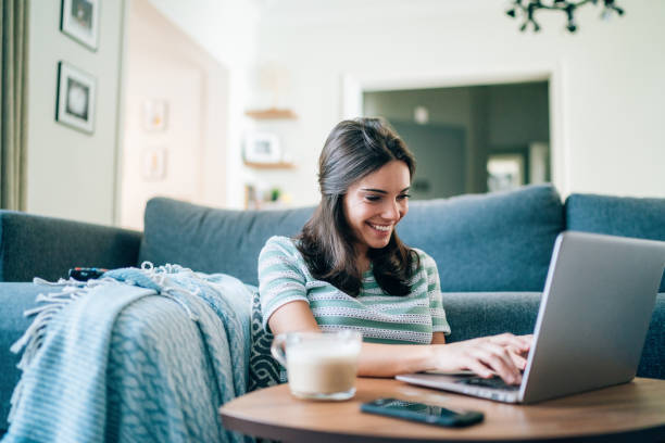 Beautiful Young Woman relaxing and surfing the net at home