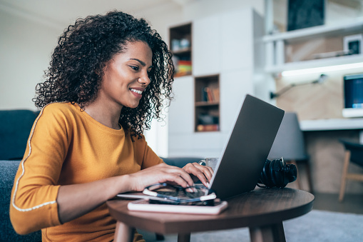 Young modern woman working from home, using laptop in quarantine